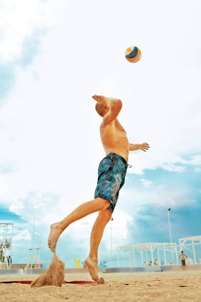 jugador de voleibol playa es un jugador de voleibol de hombres atleta preparándose servir a la pelota en la playa. - volley kick fotografías e imágenes de stock