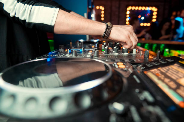istock control DJ for mixing music with blurred people dancing at party in nightclub 1094364708