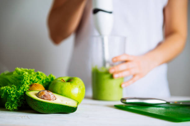 istock smoothie ingredients in front. woman making smoothie on backgrou 1094364860