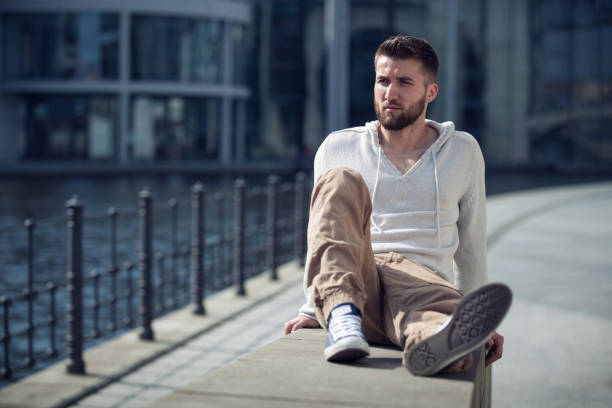 istock Attractive man with beard is sitting on a wall in Berlin 1094368496