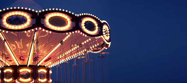 illuminated french carousel at night. toned image
