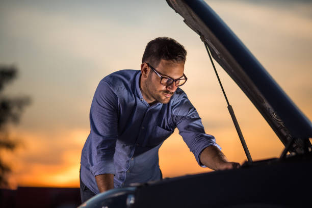 istock Young man repairing his broken car at sunset. 1094386510