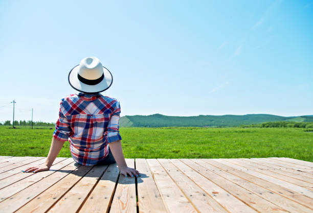 istock Woman looking away while sitting on wooden platform 1094386528