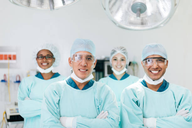 istock Four health workers standing in operation room and smiling at camera 1094386546