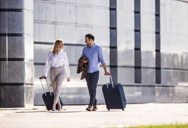 istock Happy business couple talking while pulling their suitcases on the street. 1094386548