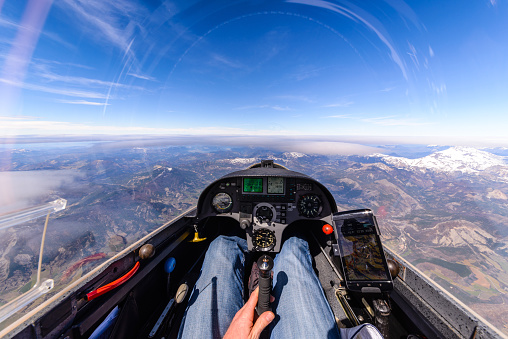 Cockpit view from a high altitude from a glider over a mountainous landscape