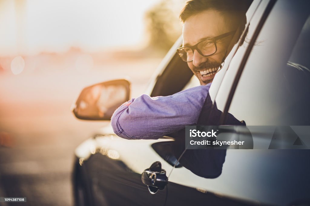 Gelukkig jongeman besturen van een auto bij zonsondergang. - Royalty-free Auto Stockfoto