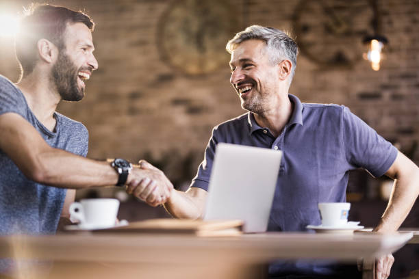 istock Happy mid adult man shaking hands in a cafe. 1094387202