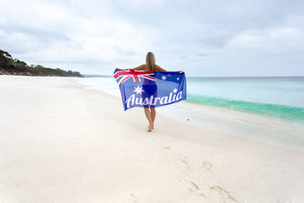 turismo australia turismo.  mujer orgullosa en la playa con la bandera - downunder fotografías e imágenes de stock