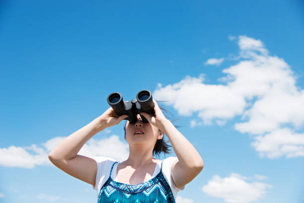 istock A woman looks at the sky with a binoculars 1094393236