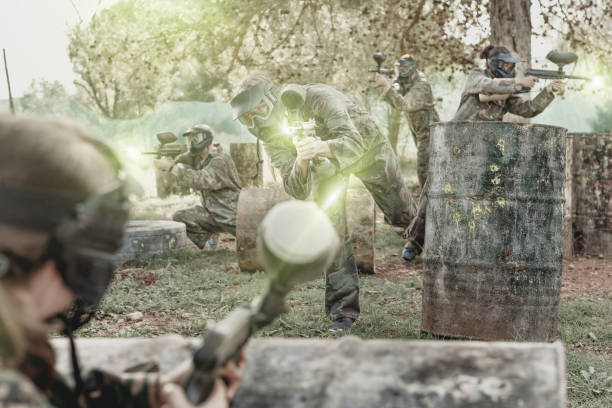 istock Paintball players aiming and shooting with guns 1094396334