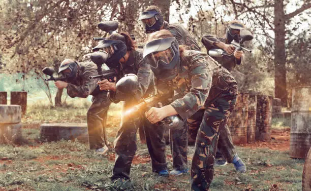 Photo of Paintball team running with marker guns