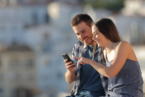 istock Happy couple browsing cell phone content in a town 1094401508
