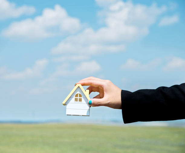 istock Woman hand holding a house model 1094407556