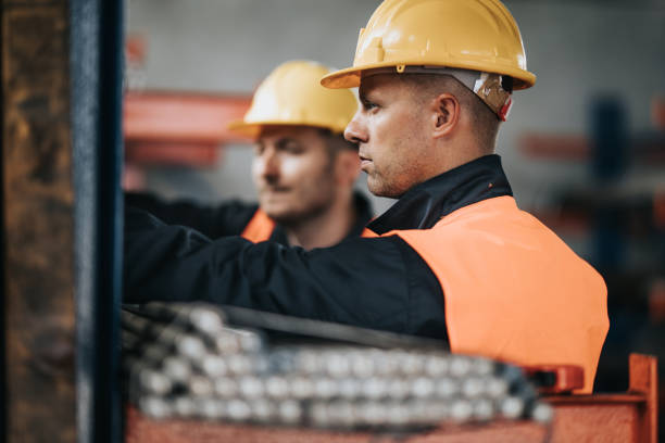 istock Manual workers cooperating while working with metal in aluminum mill. 1094410074
