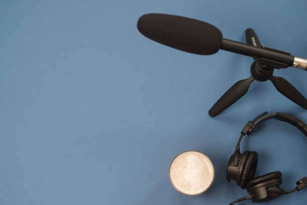 istock Flat lay composition with Headphones, microphone and coffee on a blue background. Podcast or webinar concept. 1094410850