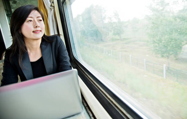 istock Young businesswoman using laptop on the train 1094415004