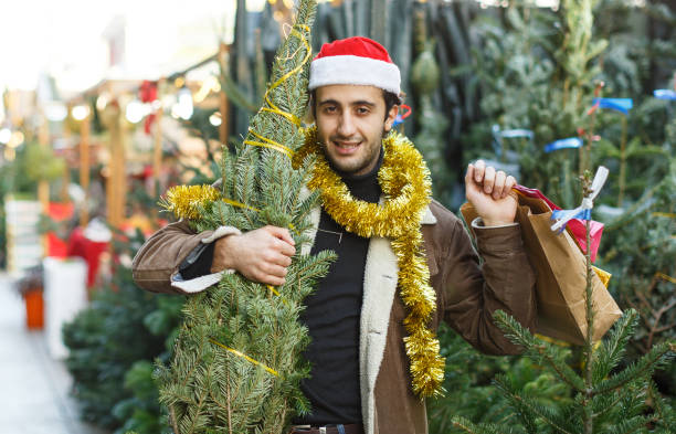 istock Man choosing decorations and Christmas tree at Christmas market 1094417846