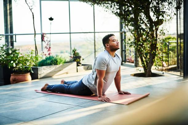 istock Young male practicing upward-facing dog position 1094418282