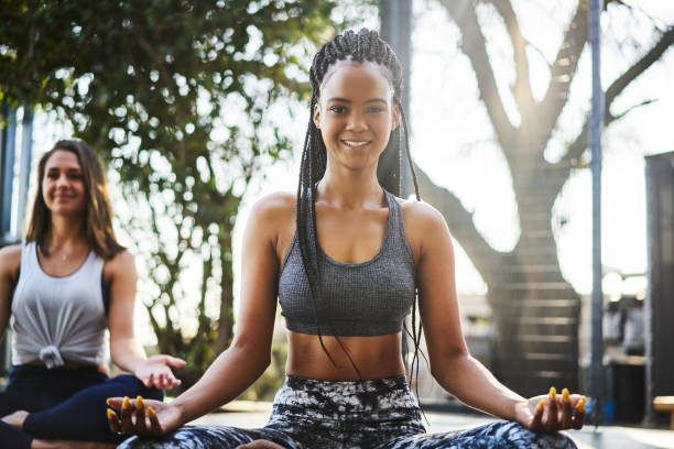 istock Young woman practicing lotus position with female 1094419058
