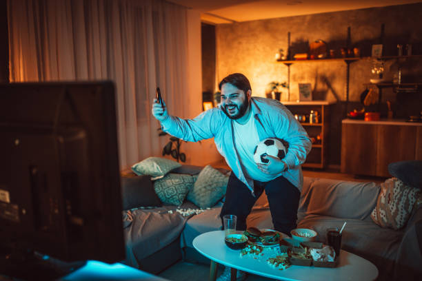 istock Fat man watching soccer game 1094423510