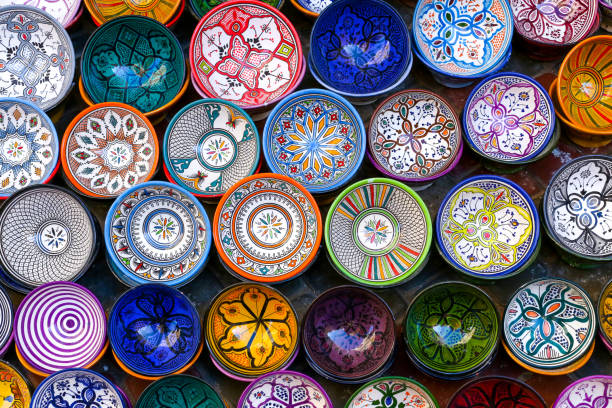 Essaouira, Morocco - October 1, 2018: Moroccan pottery in Essaouira. Colorful ceramics and pottery displayed outside a shop. Beautiful oriental design with plenty of colors. Essaouira, Morocco - October 1, 2018: Moroccan pottery in Essaouira. Colorful ceramics and pottery displayed outside a shop. Beautiful oriental design with plenty of colors. tajine stock pictures, royalty-free photos & images