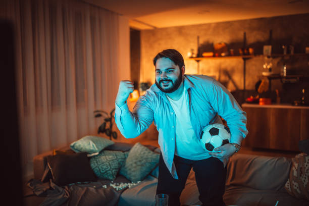 istock Fat man watching soccer game 1094424440