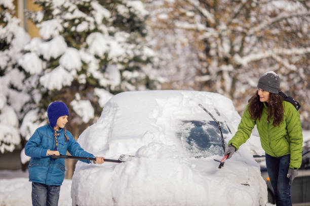 istock Woman cleaning her car from snow 1094431024
