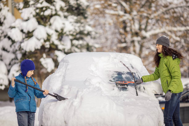 istock Woman cleaning her car from snow 1094431128