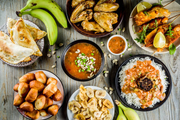 West african food assortment West african food concept. Traditional Wset African dishes assortment - peanut soup, jollof rice, grilled chicken wings, dry fried bananas plantains, nigerian chicken kebabs, meat pies, top view nigeria stock pictures, royalty-free photos & images