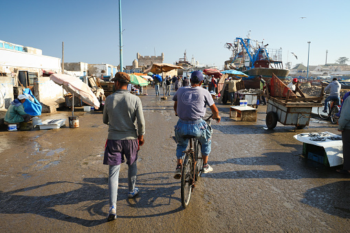 Essaouira, Morocco - October 2, 2018: Two harbor workers in Essaouira harbor after returning from sea