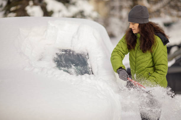 istock Woman cleaning her car from snow 1094436188