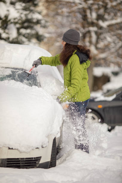 istock Woman cleaning her car from snow 1094437346