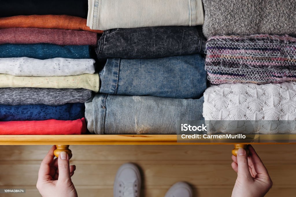 Neatly ordered clothes in drawer Overhead shot of neatly ordered clothes in wooden drawer. Woman organizing clothes in drawer Clothing Stock Photo