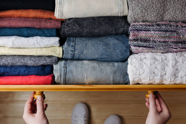 Neatly ordered clothes in drawer Overhead shot of neatly ordered clothes in wooden drawer. Woman organizing clothes in drawer dresser stock pictures, royalty-free photos & images
