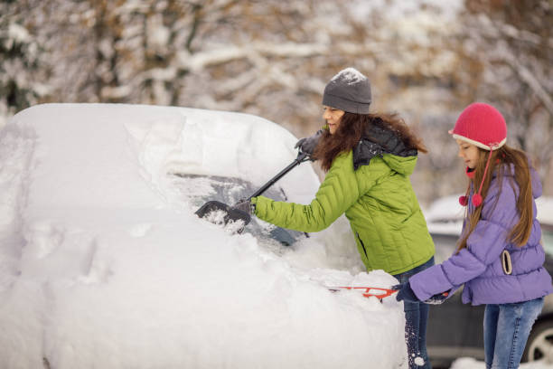istock Woman cleaning her car from snow 1094438898