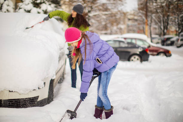 istock Woman cleaning her car from snow 1094439066