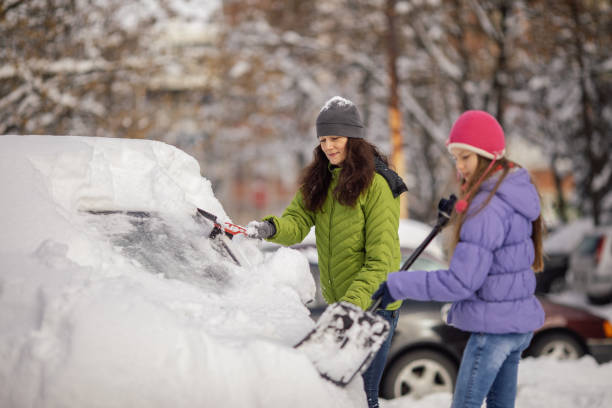 istock Woman cleaning her car from snow 1094439248