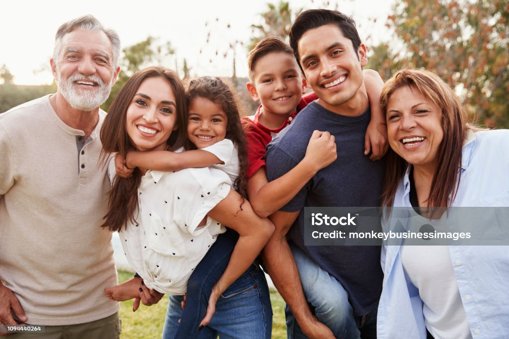 Three generation Hispanic family standing in the park, smiling to camera, selective focus Latin American and Hispanic Ethnicity Stock Photo