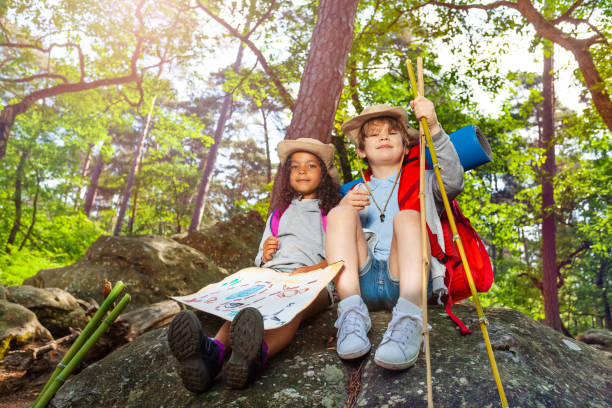 istock Kids rest during hike boy and girl with map 1094443574