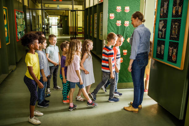 istock Happy female teacher welcoming elementary students in the classroom. 1094445110