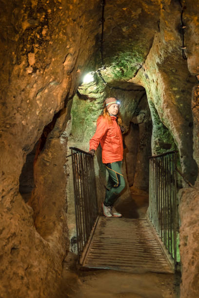 istock Young tourist woman explore ancient underground cave 1094445136