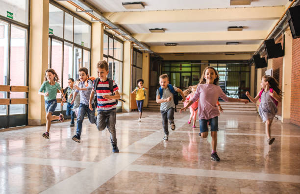 istock Large group of elementary students running in the school hallway. 1094445386