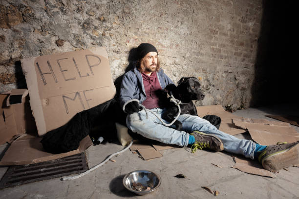 istock Tramp hugging his dog sitting on the city sidewalk 1094446846