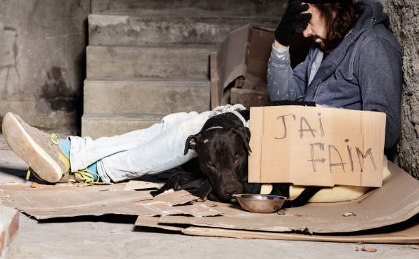 istock Clochard sitting with his dog on backstreet yard 1094446852
