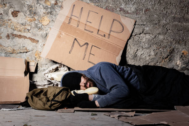 istock Beggar in tattered clothes sleeping at sidewalk 1094446862
