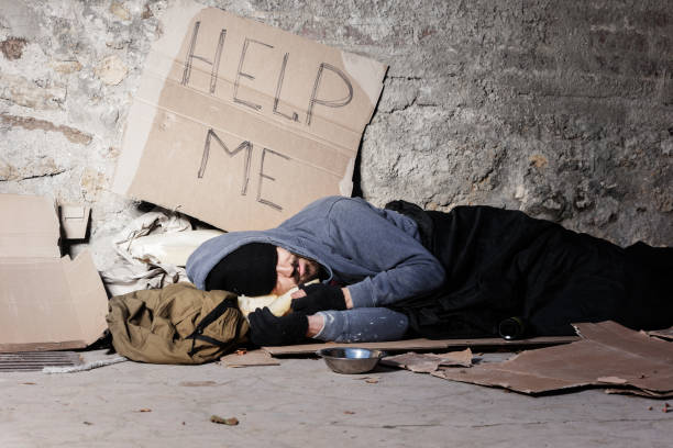 istock Beggar man in old clothes sleeping on the street 1094446874