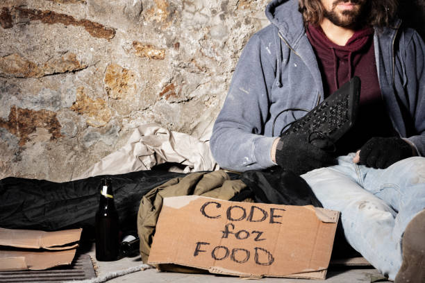 istock Jobless man sits with keyboard and cardboard sign 1094446886