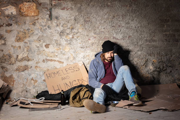 istock Unhappy man sitting on the floor with alms basket 1094446892