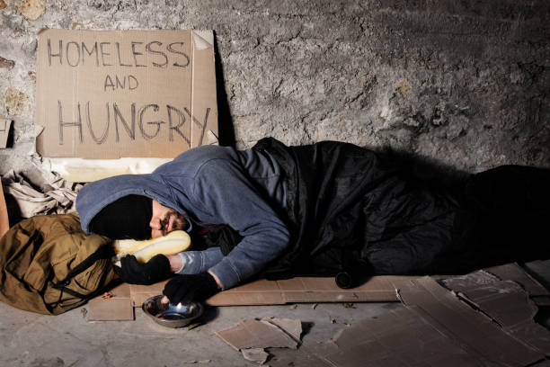 istock Houseless man sleeping on the street with alms box 1094446898